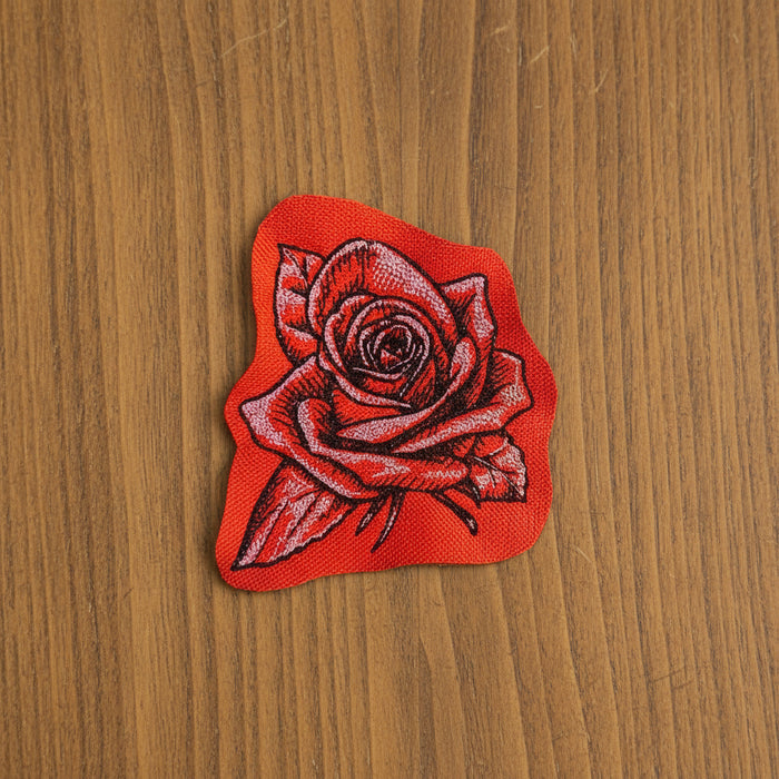 Red rose patch on a wooden surface